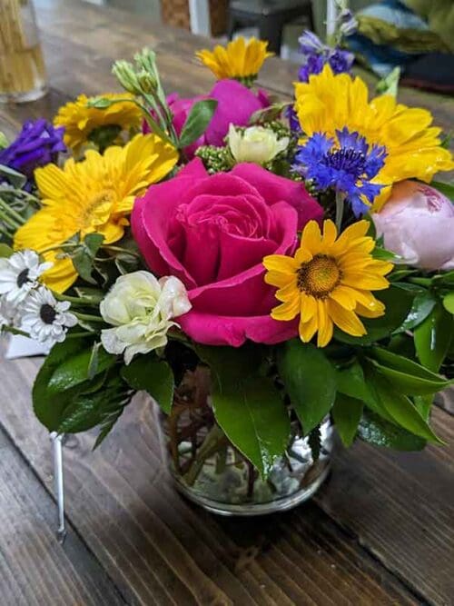 Flower arrangement with colorful bold blossoms in a glass vase
